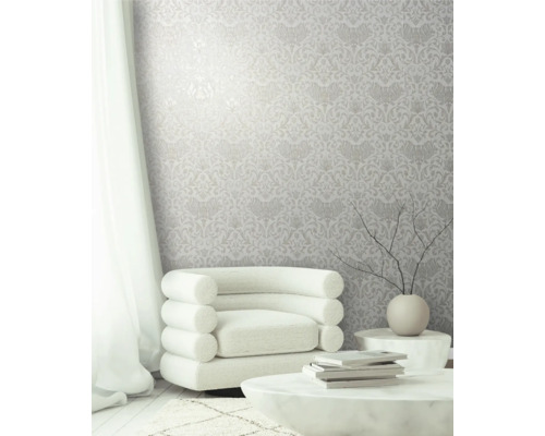 Pièce lumineuse avec papier peint à motifs floraux, fauteuil et table