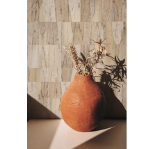 Vase décoratif avec fleurs séchées sur une table devant un mur structuré