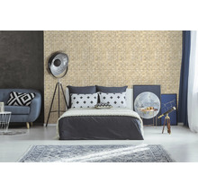 Chambre avec mur en mosaïque, lit, canapé et objets de décoration pour une ambiance lumineuse et accueillante.
