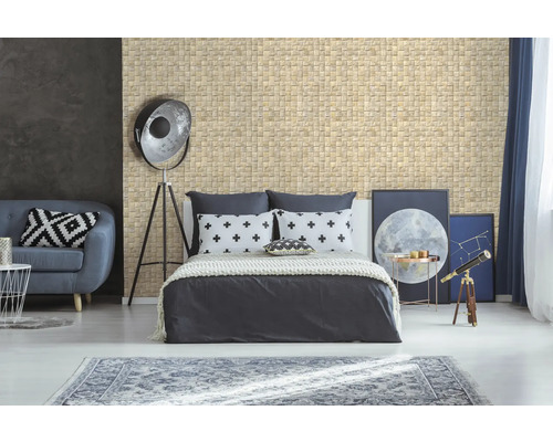 Chambre avec mur en mosaïque, lit, canapé et objets de décoration pour une ambiance lumineuse et accueillante.