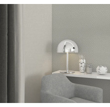 Salon moderne avec fauteuil, lampe et vases décoratifs sur une étagère