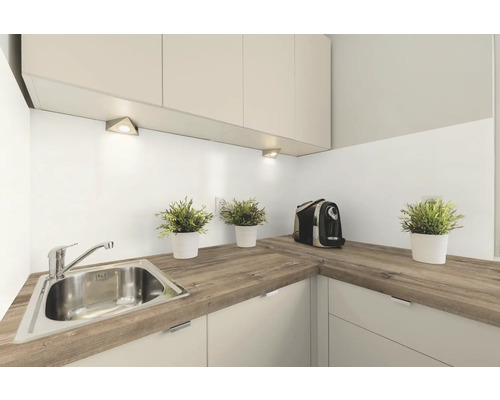 Helle Küche mit Spüle, Arbeitsplatte in Holzoptik und Küchengeräten.