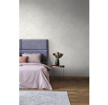 Helles Schlafzimmer mit Doppelbett, Nachttisch und gemusterter Tapete