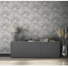 Wohnzimmer mit gemusterter Tapete, Sideboard, Lampe und Dekorationen