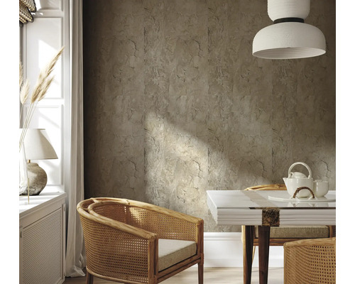 Salon avec carrelage mural aspect pierre, fauteuils en rotin et table à manger avec service à thé.