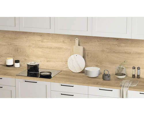 Küchenszene mit Arbeitsplatte in Holzoptik, Kochutensilien und weißen Schränken