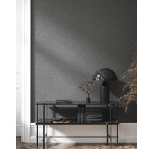 Étagère avec objets de décoration, livres et lampe devant un mur gris