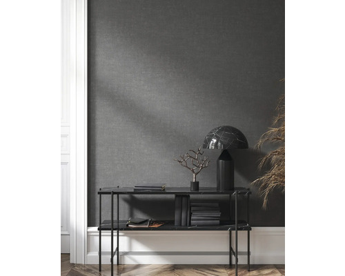 Étagère avec objets de décoration, livres et lampe devant un mur gris