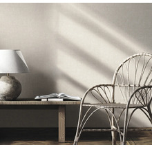 Innenraumszene mit Lampe, Buch und Rattan-Stuhl