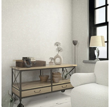 Espace de vie avec un papier peint à motifs, une table d''appoint et des éléments décoratifs.