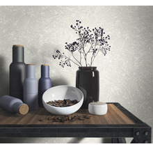 Scène décorative avec des vases, un bol et des éléments floraux sur une table en bois
