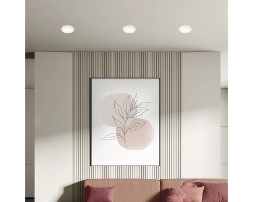 Wohnzimmer mit Deckeneinbaustrahlern, Wandpaneelen, gerahmtem Bild und Sofa