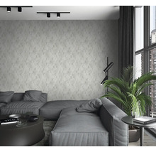 Salon moderne avec canapé gris, panneaux muraux hexagonaux et grandes fenêtres