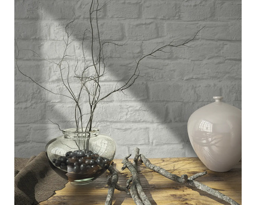 Arrangement décoratif avec un vase en verre, des branches et un vase en céramique sur une table en bois