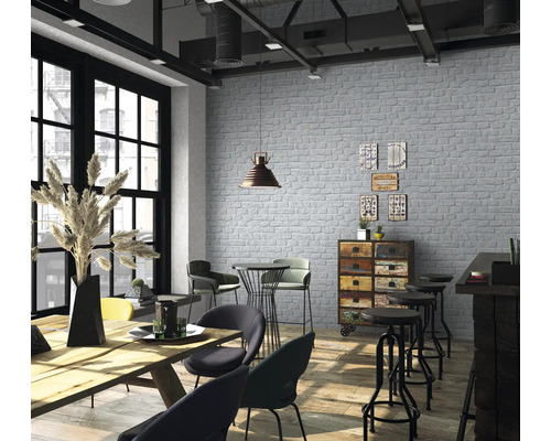 Pièce lumineuse avec papier peint en briques, table en bois et chaises