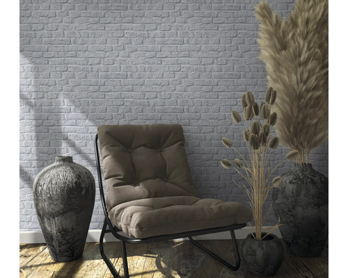 Intérieur décoratif avec fauteuil, vases et papier peint en briques.