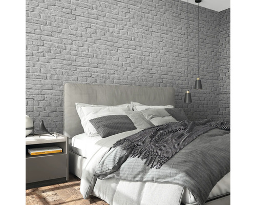 Chambre à coucher avec lit, table de chevet et papier peint en briques grises