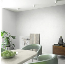 Salle à manger lumineuse avec table, chaises, commode, plantes et spots de plafond