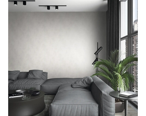 Wohnzimmer mit grauer Couch, Stehlampe, Zimmerpflanze und Deckenleuchten.