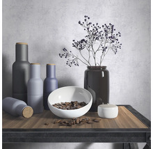 Nature morte décorative avec des vases, un bol et des plantes sur une table.