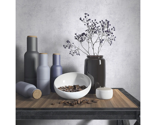 Nature morte décorative avec des vases, un bol et des plantes sur une table.