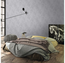 Chambre avec lit, table de chevet, tabouret et applique devant un mur gris