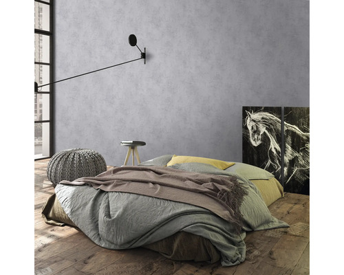 Chambre avec lit, table de chevet, tabouret et applique devant un mur gris