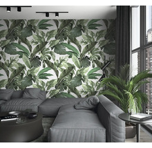Salon avec canapé, table, plante d''intérieur et papier peint mural à imprimé feuilles
