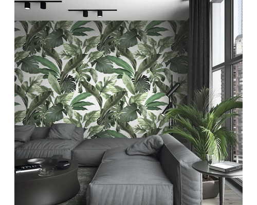 Salon avec canapé, table, plante d''intérieur et papier peint mural à imprimé feuilles