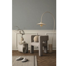 Wohnzimmer mit Sessel, Bogenlampe, Beistelltisch, Dekoration und Teppich für eine gemütliche Atmosphäre