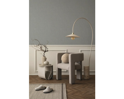 Wohnzimmer mit Sessel, Bogenlampe, Beistelltisch, Dekoration und Teppich für eine gemütliche Atmosphäre