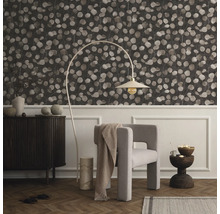 Wohnzimmer mit gemusterter Tapete, Sessel, Stehlampe und Kommode