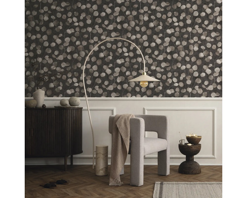 Wohnzimmer mit gemusterter Tapete, Sessel, Stehlampe und Kommode