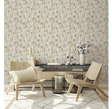 Ein Wohnraum mit geometrischer Tapete, zwei Holzstühlen und einem Teppich.