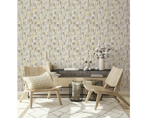 Ein Wohnraum mit geometrischer Tapete, zwei Holzstühlen und einem Teppich.