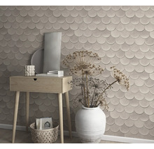 Dekorative Wandgestaltung mit Tapete in Schuppenoptik, kombiniert mit einer Holzkommode und dekorativen Elementen.