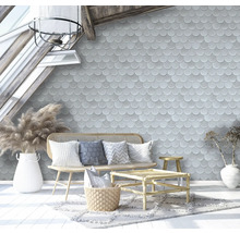 Wohnzimmer mit Schuppentapete, Rattanmöbeln und dekorativen Accessoires unter einem Dachfenster