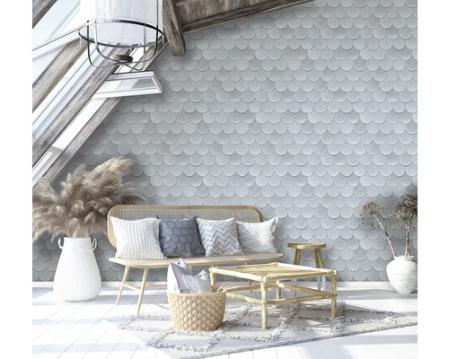 Wohnzimmer mit Schuppentapete, Rattanmöbeln und dekorativen Accessoires unter einem Dachfenster