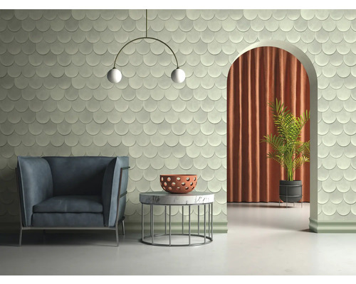 Helles Zimmer mit Sessel, Tisch, Zimmerpflanze und Wandfliesen in Schuppenoptik