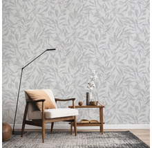 Wohnzimmer mit Sessel, Stehlampe und Wandtapete mit Blättermuster