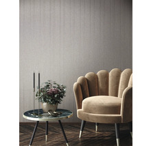 Szene mit einer Wandtapete, einem Sessel und einem Beistelltisch mit Dekoration