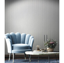 Einrichtungsbeispiel mit Sessel, Tisch und Wandtapete in einem hellen Raum.