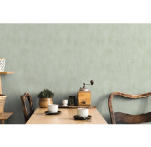 Helle, freundliche Essecke mit Holztisch, Stühlen, Geschirr und Dekoration vor einer dezenten Wand