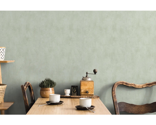 Helle, freundliche Essecke mit Holztisch, Stühlen, Geschirr und Dekoration vor einer dezenten Wand