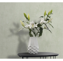 Stillleben mit weißen Lilien in einer weißen Vase auf einem Tisch