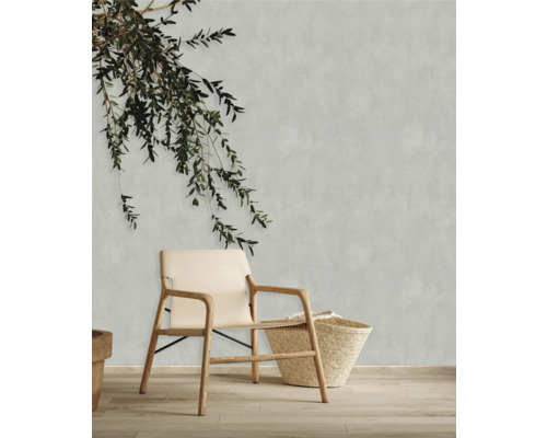 Dekorative Szene mit Stuhl, Korb und Zweigen vor einer Wand