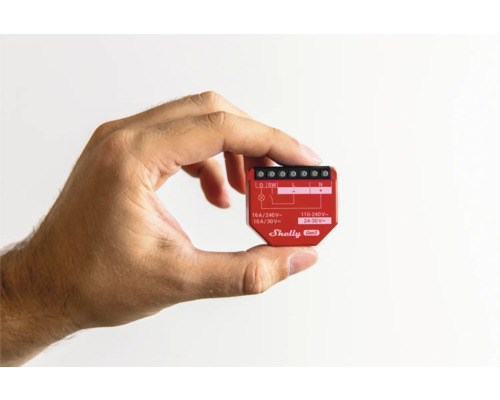 Une main tient un interrupteur de maison intelligente Shelly Gen3.