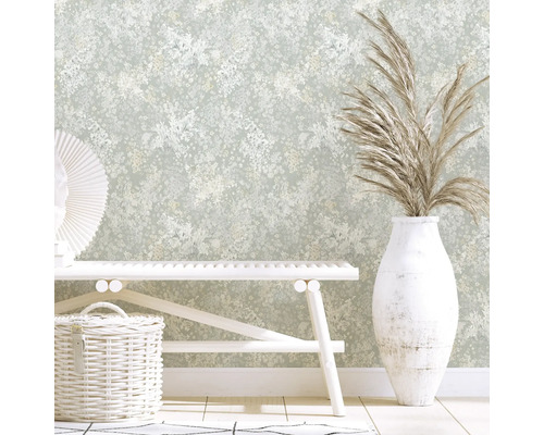 Pièce décorative avec papier peint floral, banc, panier et vase avec des graminées ornementales.