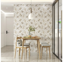 Coin repas lumineux avec table en bois, chaise et banc devant un papier peint à motifs.