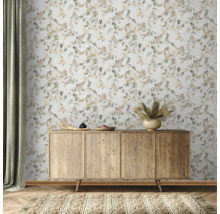 Scène avec un buffet en bois devant un papier peint floral et un tapis.